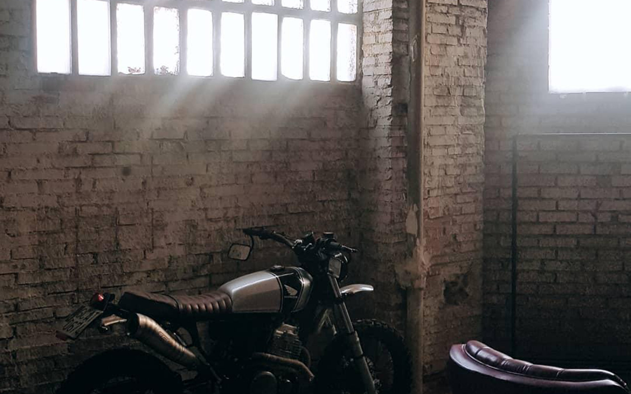 Imagen de una moto apoyada contra una pared